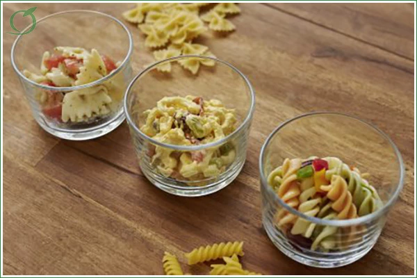 Das Bild zeigt drei verschiedene Nudelsalate in kleinen Gläsern