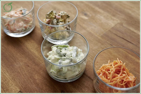 Bild zeigt vier Gläser mit verschiedenen Rohkostsalaten mit Salatcreme in kleinen Gläsern