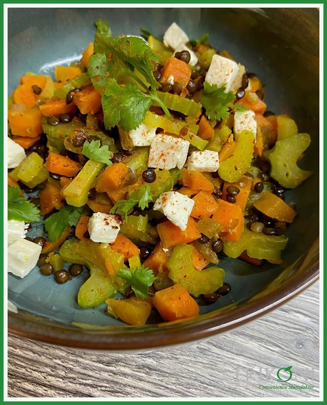 Das Bild zeigt den Belugasalat, angerichtet auf einem türkisfarbenen Teller mit braunen Rand.