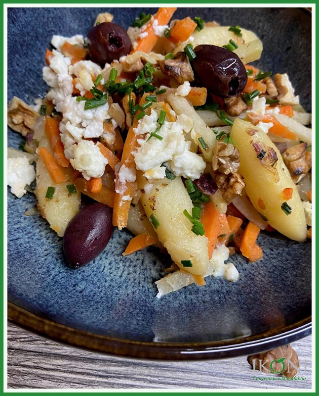 Bild zeigt die fertigen Schupfnudeln auf einem blauen Teller mit braunem Rand, garniert mit Walnüssen, Kürbis- und Pinienkernen