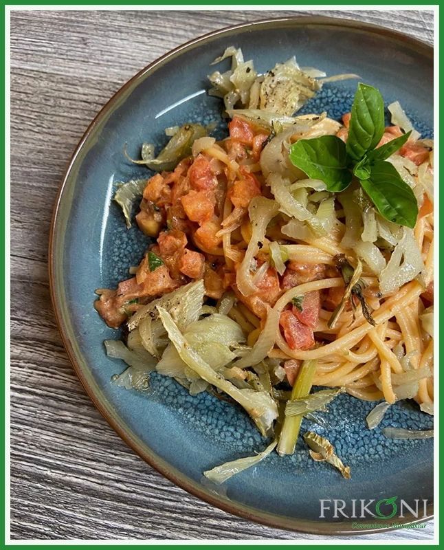 Bild zeigt die zubereiteten Spaghetti, angerichtet auf einem blauen Teller mit braunem Rand. Garniert mit frischen Basiliku-Blättern.